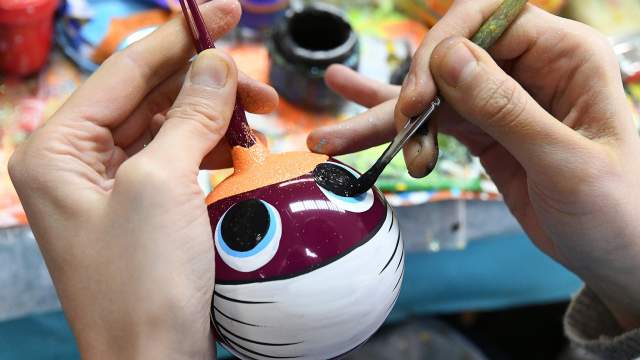 Художница расписывает стеклянный новогодний шар