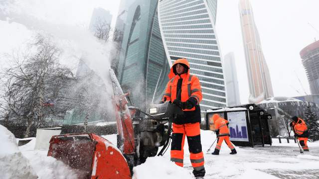 Сотрудники коммунальной службы убирают снег с площади у делового центра "Москва-сити"