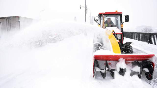 Снегоуборочная техника расчищает от снега и наледи Крымский мост во время снегопада в Москве