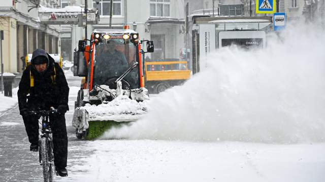 Снегоуборочная машина чистит улицу в центре Москвы