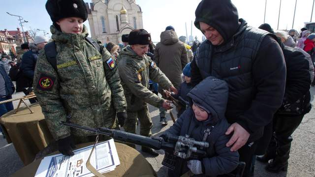 Горожане на выставке оружия во время празднования Дня защитника Отечества на центральной площади во Владивостоке. На первом плане — специальная бесшумная снайперская винтовка ВСС (6П29)