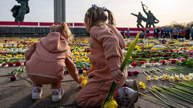 Дети возлагают цветы у мемориального комплекса "Памятник воинам Советской Армии - освободителям Советской Латвии и Риги от немецко-фашистских захватчиков" в Риге.