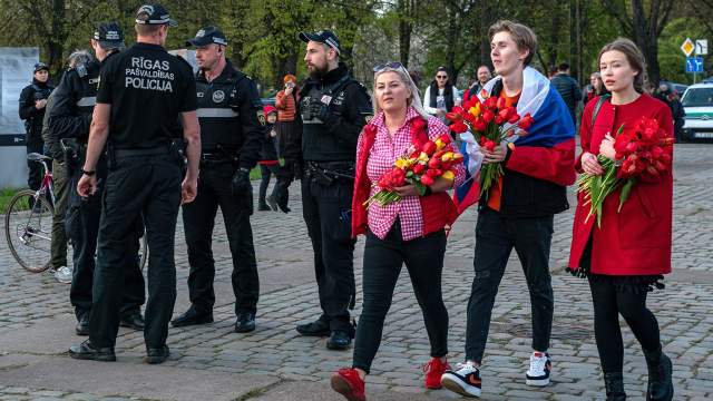 Сотрудники полиции и участники церемонии возложения цветов у мемориального комплекса "Памятник воинам Советской Армии - освободителям Советской Латвии и Риги от немецко-фашистских захватчиков" в Риге.
