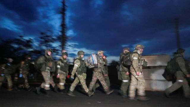 Service members of pro-Russian troops walk before the expected departure of Ukrainian soldiers, who surrendered at the besieged Azovstal steel mill, in the course of Ukraine-Russia conflict in Mariupol