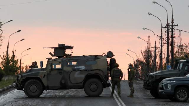 Service members of pro-Russian troops stand guard before the expected departure of Ukrainian soldiers, who surrendered at the besieged Azovstal steel mill, in the course of Ukraine-Russia conflict in Mariupol