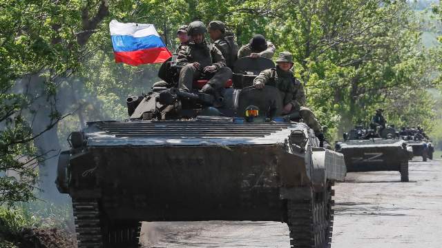 A convoy of Russian armoured vehicles drives along a road in the course of Ukraine-Russia conflict near Mariupol in the Donetsk region