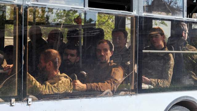 A bus carrying service members of the Ukrainian armed forces, who surrendered at the besieged Azovstal steel mill, drives away under escort of the pro-Russian military in the course of the Ukraine-Russia conflict, in Mariupol