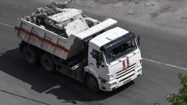 Автомобиль МЧС РФ везет обломки разрушенного здания