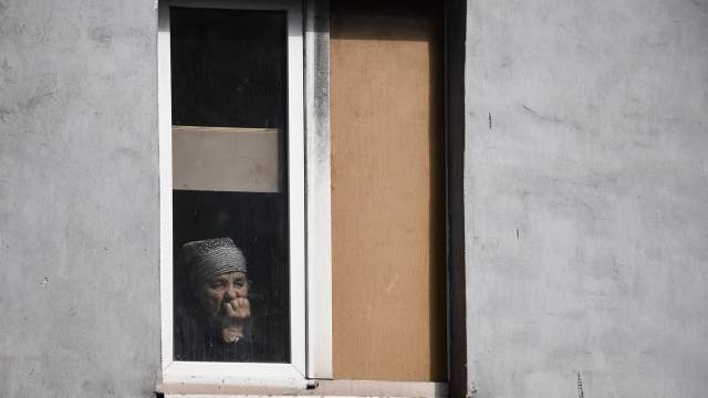 Женщина в окне жилого дома в Мариуполе