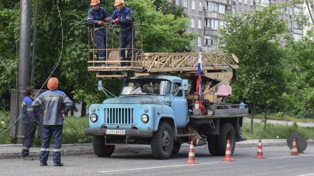Сотрудники предприятия электрических сетей наружного освещения «Горсвет» на одной из улиц в Мариуполе