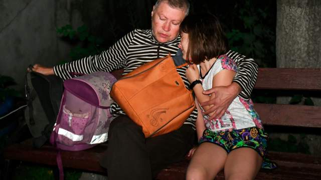 Люди на улице возле дома, пострадавшего в результате обстрела ВСУ Донецка