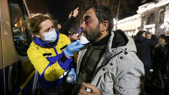 A man affected by tear gas receives medical aid during a rally against the "foreign agents" law in Tbilisi, Georgia, March 7