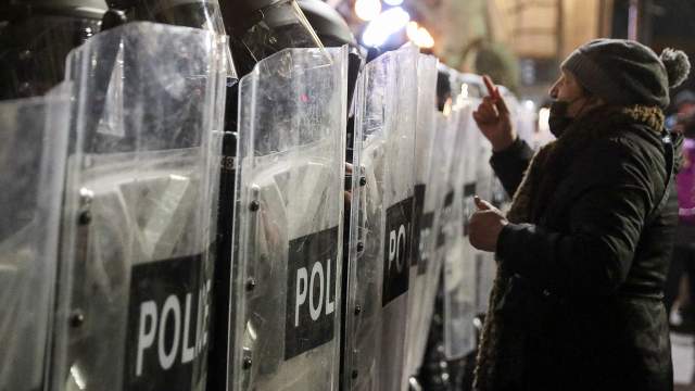 A person addresses police officers, who stand guard outside the parliament building during a rally against the "foreign agents" law in Tbilisi, Georgia, March 8