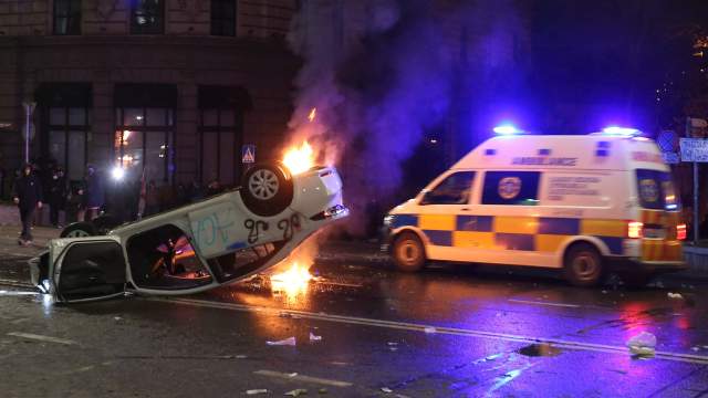 An ambulance drives past an overturned car set on fire during a protest against a draft law on "foreign agents", which critics say represents an authoritarian shift and could hurt Georgia's bid to join the European Union, in Tbilisi, Georgia, March 9
