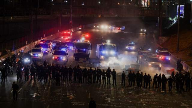 Members of security forces stand guard as people attend a demonstration after Israeli Prime Minister Benjamin Netanyahu dismissed the defense minister and his nationalist coalition government presses on with its judicial overhaul, in Tel Aviv,
