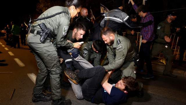 Police officers detain a protester during a demonstration after Israeli Prime Minister Benjamin Netanyahu dismissed the defense minister and his nationalist coalition government presses on with its judicial overhaul, in Jerusalem