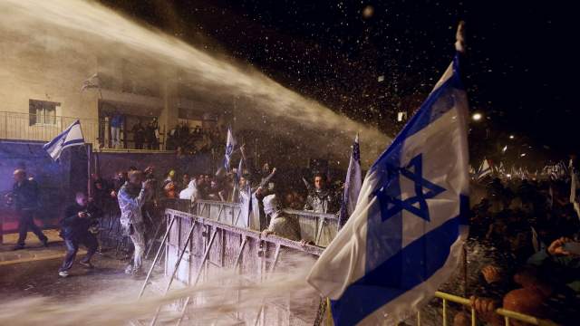 People take part in a demonstration after Israeli Prime Minister Benjamin Netanyahu dismissed the defense minister and his nationalist coalition government presses on with its judicial overhaul, in Jerusalem
