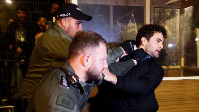 Police officers detain a protester during a demonstration after Israeli Prime Minister Benjamin Netanyahu dismissed the defense minister and his nationalist coalition government presses on with its judicial overhaul, in Jerusalem