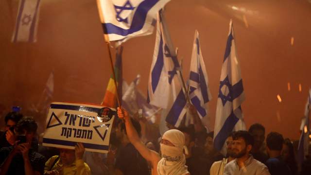 People attend a demonstration after Israeli Prime Minister Benjamin Netanyahu dismissed the defense minister and his nationalist coalition government presses on with its judicial overhaul, in Tel Aviv,