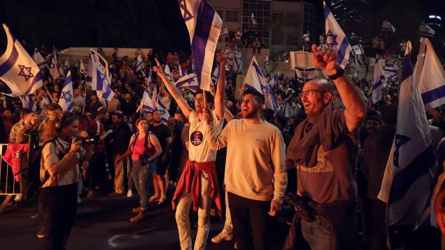 People attend a demonstration after Israeli Prime Minister Benjamin Netanyahu dismissed the defense minister and his nationalist coalition government presses on with its judicial overhaul, in Tel Aviv,