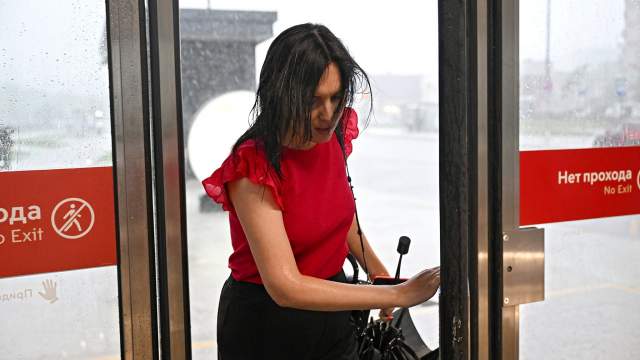 Девушка входит в метро «Новаторская» во время ливня в Москве