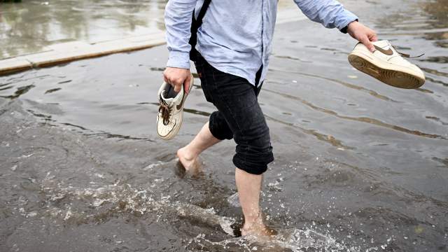 Прохожий на подтопленной улице в результате ливня в Москве