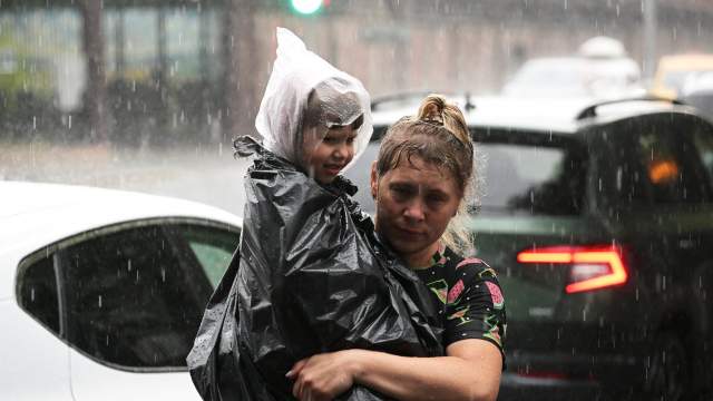 Женщина с ребенком во время сильного ливня в Москве