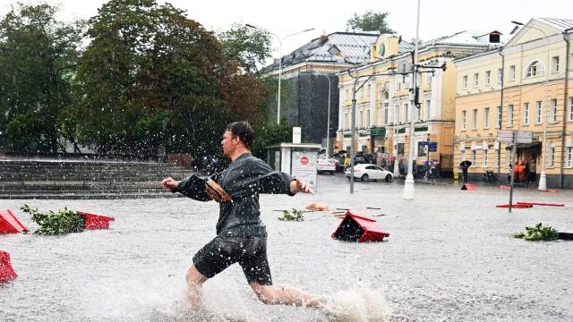 Мужчина на подтопленной улице в результате ливня в Москве.