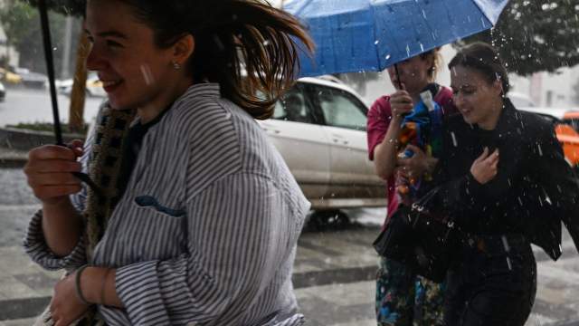 Люди бегут по Зубовскому бульвару во время дождя в Москве.