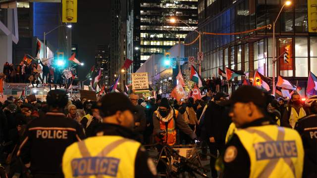 Полиция Торонто стоит на страже, когда сотни людей собираются возле генерального консульства Израиля в Торонто, Онтарио, чтобы продемонстрировать солидарность с палестинцами в секторе Газа и осудить недавние действия правительства Израиля