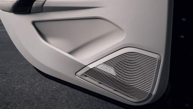 На крышку динамика нанесено название машины. Карман в двери слишком узкий для бутылки с водой