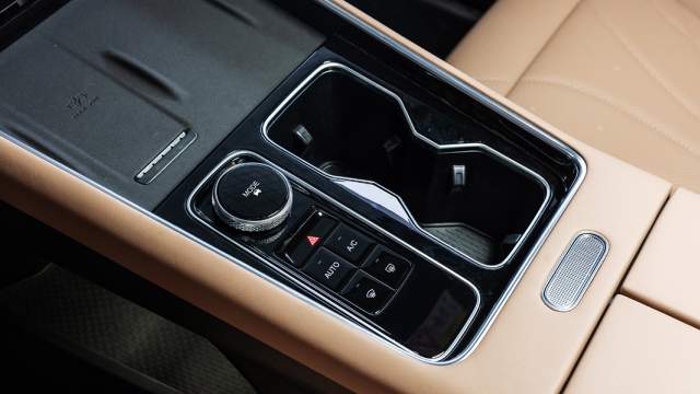 На центральном тоннеле расположена площадка для беспроводной зарядки смартфона, «шайба» выбора режимов движения и кнопки включение кондиционера, обогрева стекол и режима рециркуляции воздуха