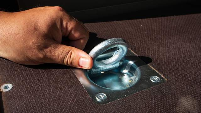 На полу расположены несколько такелажных петель для крепления груза