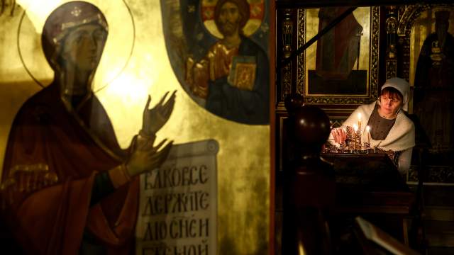 Россия. Рязань. Прихожанка во время зажжения свечей после праздничного богослужения по случаю Рождества Христова в Николо-Ямской церкви. 