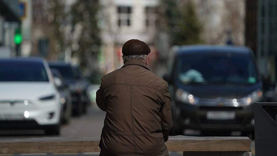 Пожилой мужчина сидит спиной