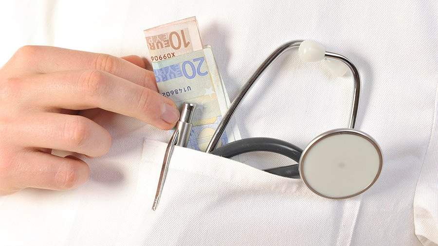 деньги и стетоскоп в кармане медицинского халата