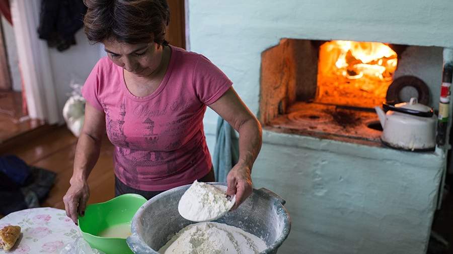Жительница деревни Сибиляково Омской области готовит обед на печи