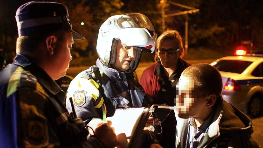 Сотрудники дорожно-патрульной службы ГИБДД проверяют водителя автомобиля на алкогольное опьянение