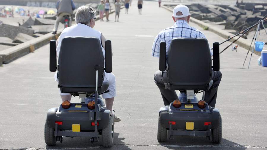 Пенсионеры на моторизованных инвалидных колясках на пляже Схевенинген, Нидерланды