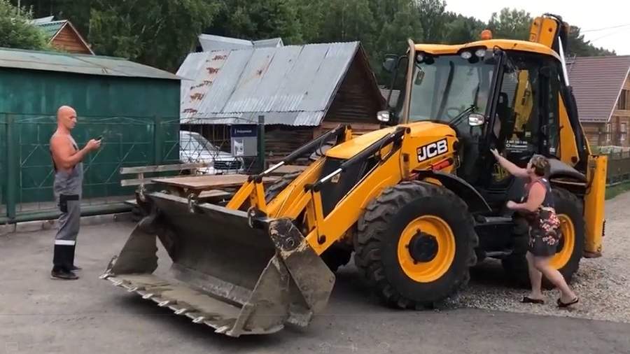 Стоп-кадр с видео, где Сергей Чапайкин на тракторе пытается задавить Артема Пакалова, а затем таранит его гараж