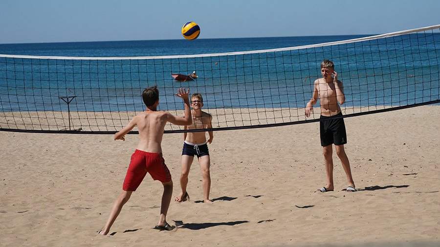 дети играют на пляже в волейбол 