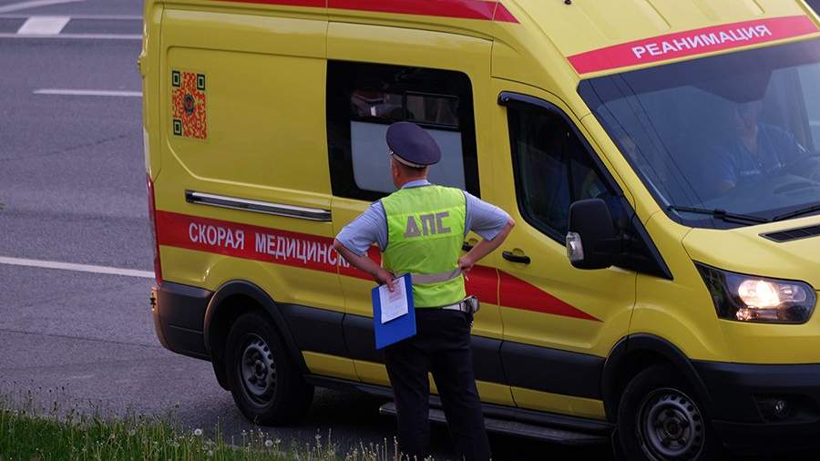 Сотрудник Дорожно-патрульной службы ГИБДД и автомобиль скорой медицинской помощи на дороге