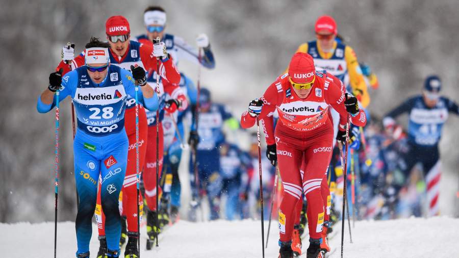 Адриен Бакшайдер из Франции и Александр Большунов из России в масс-старте мужских лыжных гонок на 15 км классической техникой во время Tour de Ski