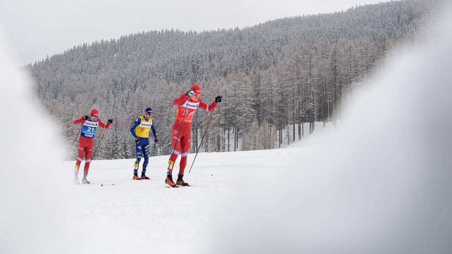 Алексей Червотикн из России, Федерико Пеллегрино из Италии и Александр Большунов из России в масс-старте мужских лыжных гонок на 15 км классической техникой во время Tour de Ski