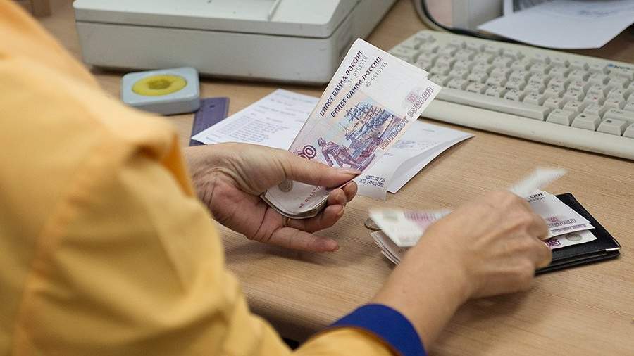 Сотрудница одного из московских отделений «Почты России» выдает ежемесячное денежное пособие