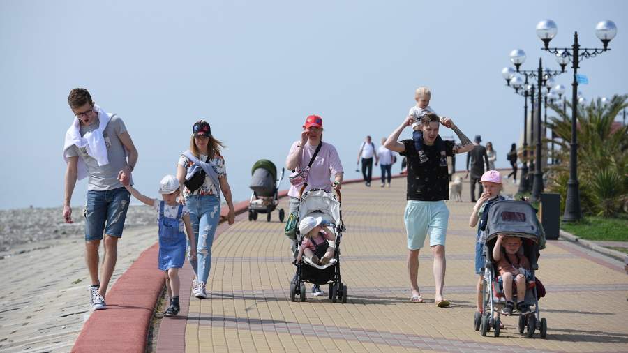Отдыхающие прогуливаются по набережной в Сочи
