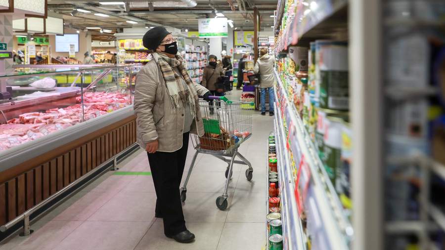 Пожилая женщина в медицинской маске в продуктовом магазине