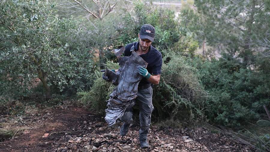 Израильская полиция собирает части ракеты, выпущенной из сектора Газа возле дома в деревне Бейт-Некуфа недалеко от Иерусалима