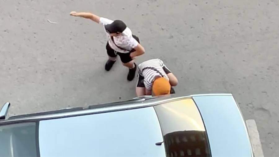 Подростки снимают колпачки ниппелей с припаркованного автомобиля