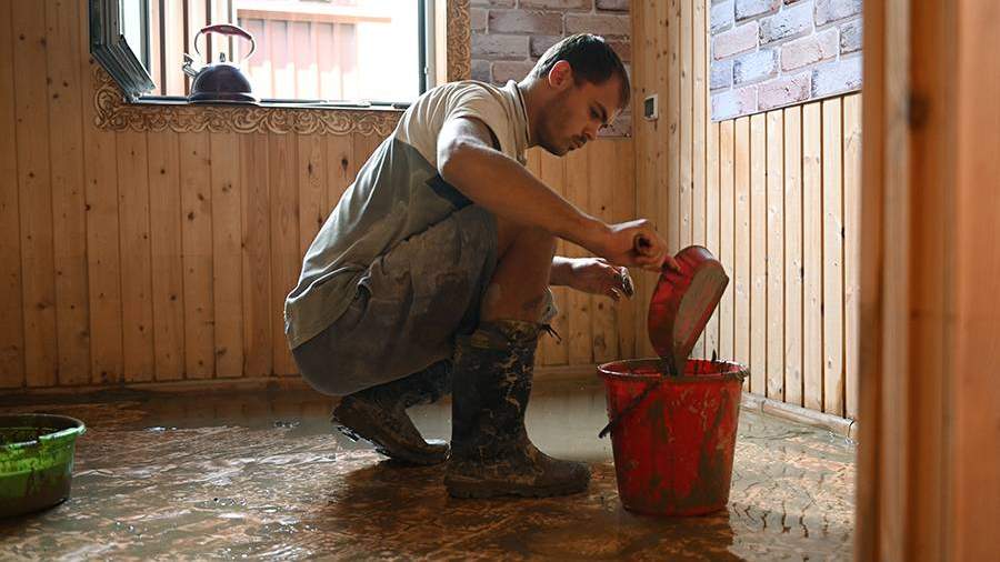 Мужчина устраняет последствия подтопления в комнате своего дома на улице Искра в поселке Кудепста Хостинского района Сочи